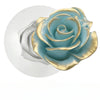 A silicone mold shaped like a blue-green rose with gold accents, resting on a white surface.