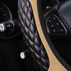 Close-up of a black quilted steering wheel cover with tan stitching and controls on the side.