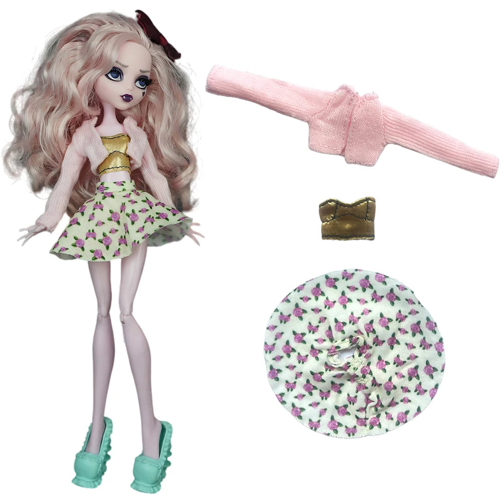 A fashion doll dressed in a pink and green floral skirt and pink cardigan, with accessories including a gold piece and a pink
