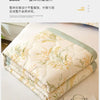 A stack of white and green quilted fabric featuring a delicate lace pattern.