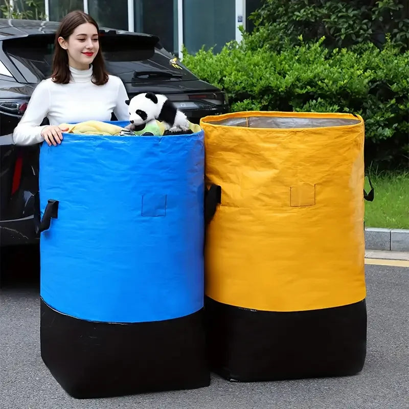 A woman stands next to two large, cylindrical waterproof storage bags, one blue and one yellow, outdoors.