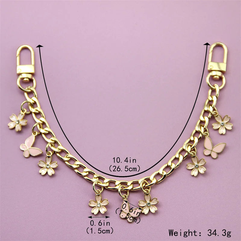 A gold-colored decorative chain necklace featuring small flower charms and a butterfly charm.