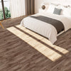 A close-up view of light brown wood grain floor tiles casting long shadows across a bedroom floor.