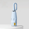 A light blue compact folding umbrella with a curved handle is shown against a white background.