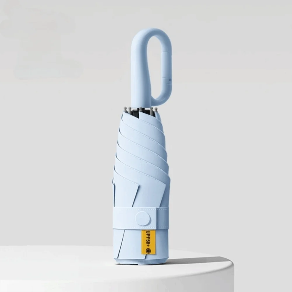A light blue compact folding umbrella with a curved handle is shown against a white background.