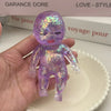 A small purple squishy stress relief toy with a shimmering finish is held in a hand against a white background.