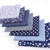 A bundle of cotton fabric squares featuring various patterns including floral, dot, plaid, and star prints.