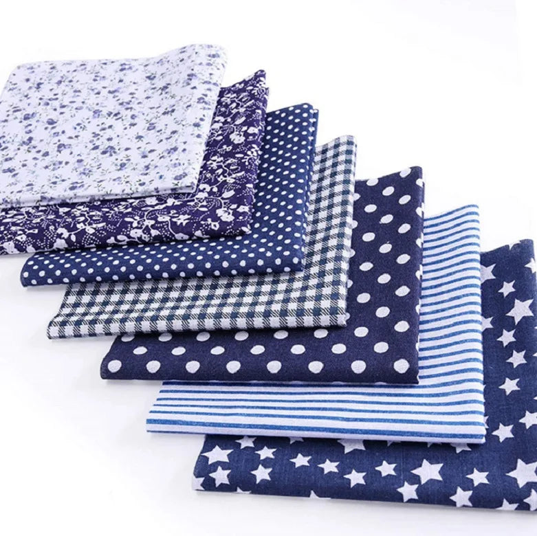 A bundle of cotton fabric squares featuring various patterns including floral, dot, plaid, and star prints.