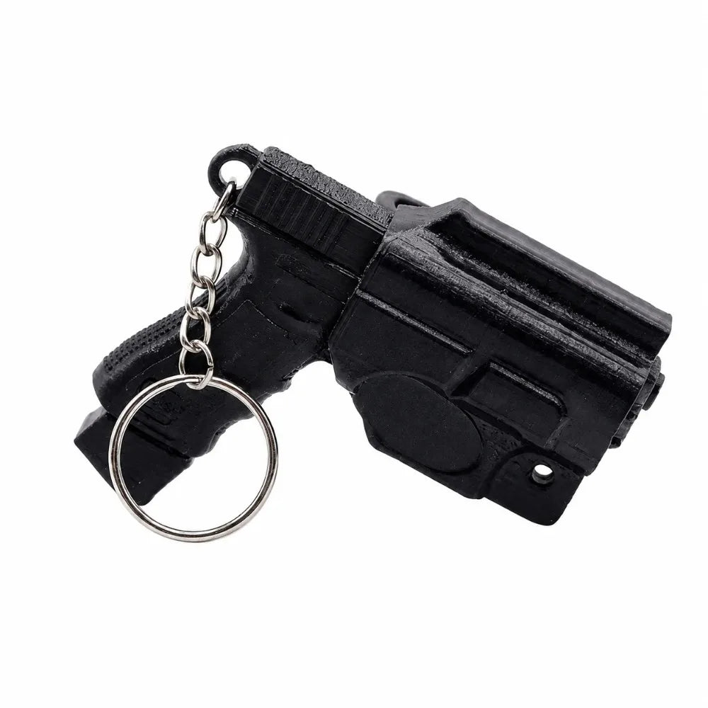 Black mini pistol-shaped keychain accessory with a metal ring attached