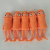 A row of orange squishy stress relief toys shaped like funny, expressive faces.