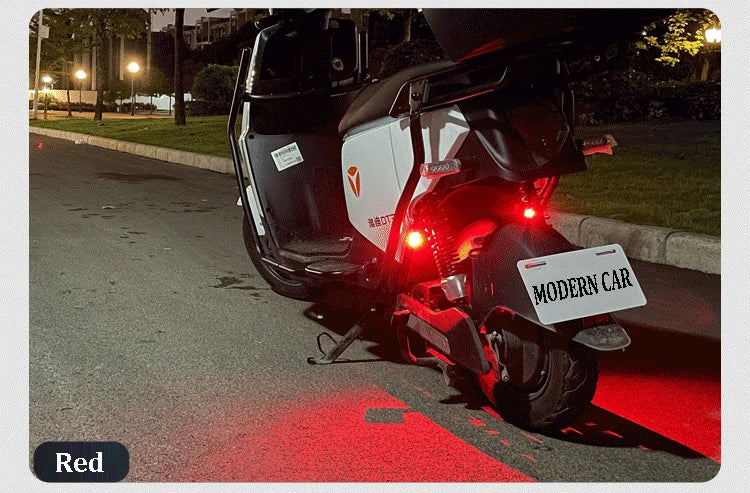 A black motorcycle with a white light is parked on an asphalt road with a red painted line.