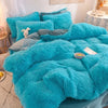 A bright turquoise plush mink velvet duvet cover set with matching sheets and pillows on a bed.