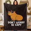 A dark gray flannel throw blanket featuring a cartoon illustration of a capybara wearing sunglasses.