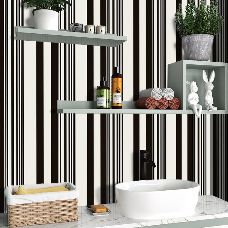 A bathroom shelf display featuring a white vessel sink, wooden storage basket, and various toiletries against black and white