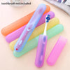 A collection of colorful portable toothbrush travel cases and a toothbrush are displayed on a light background.