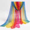 A colorful sheer fabric playsilk draped in vertical stripes of blue, green, yellow, orange, and pink.