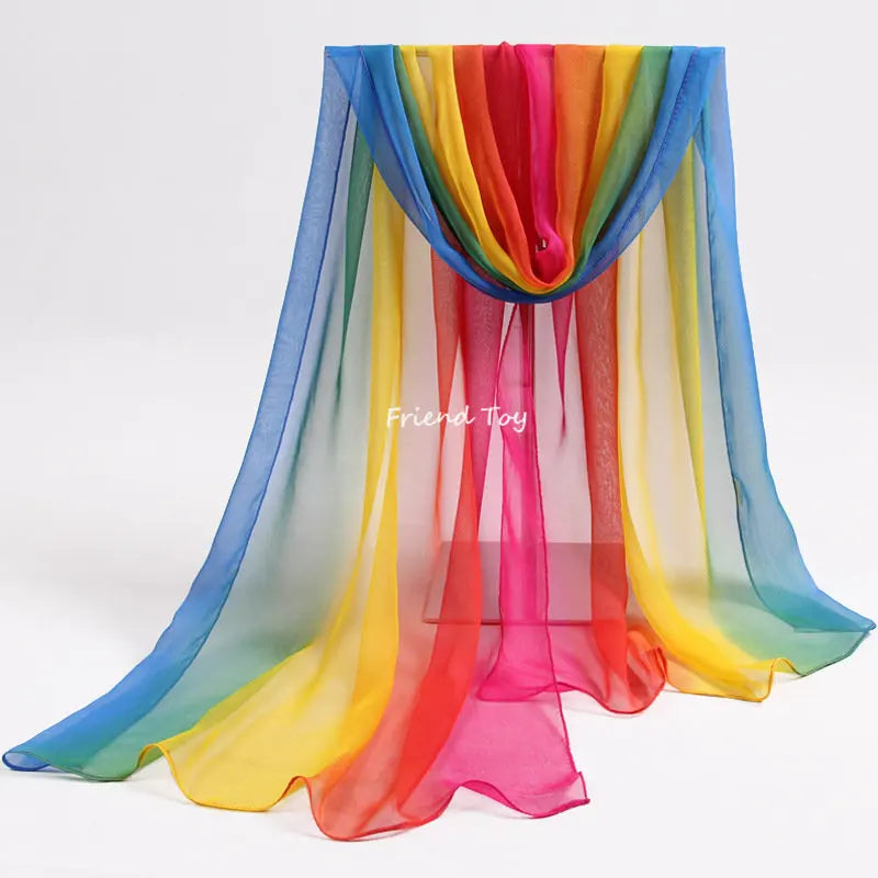 A colorful sheer fabric playsilk draped in vertical stripes of blue, green, yellow, orange, and pink.