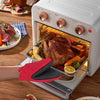 A pair of red and black heat-resistant silicone oven mitts are shown resting on a baking tray inside an open electric oven.