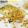 Gold acrylic crushed ice gems scattered on a white surface next to a gold mirror.
