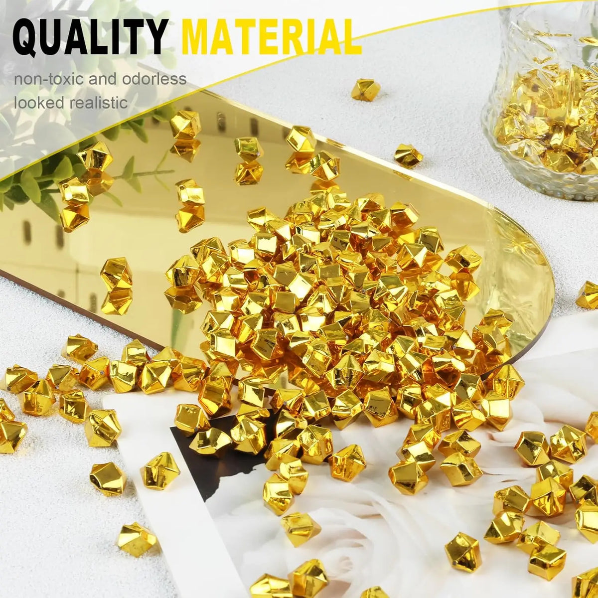 Gold acrylic crushed ice gems scattered on a white surface next to a gold mirror.