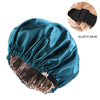 A teal satin sleep bonnet with an elastic band is shown, folded open to reveal the lining.