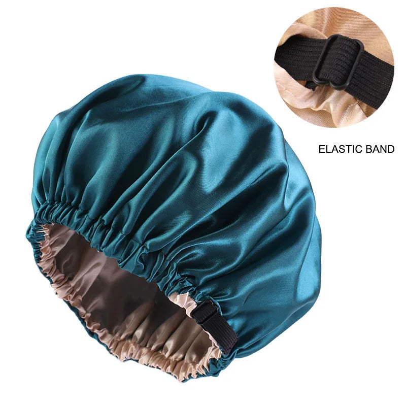 A teal satin sleep bonnet with an elastic band is shown, folded open to reveal the lining.