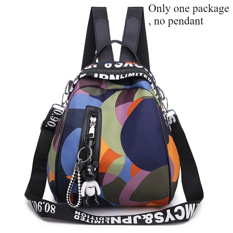 A black backpack with a colorful, abstract pattern and a black strap is shown.