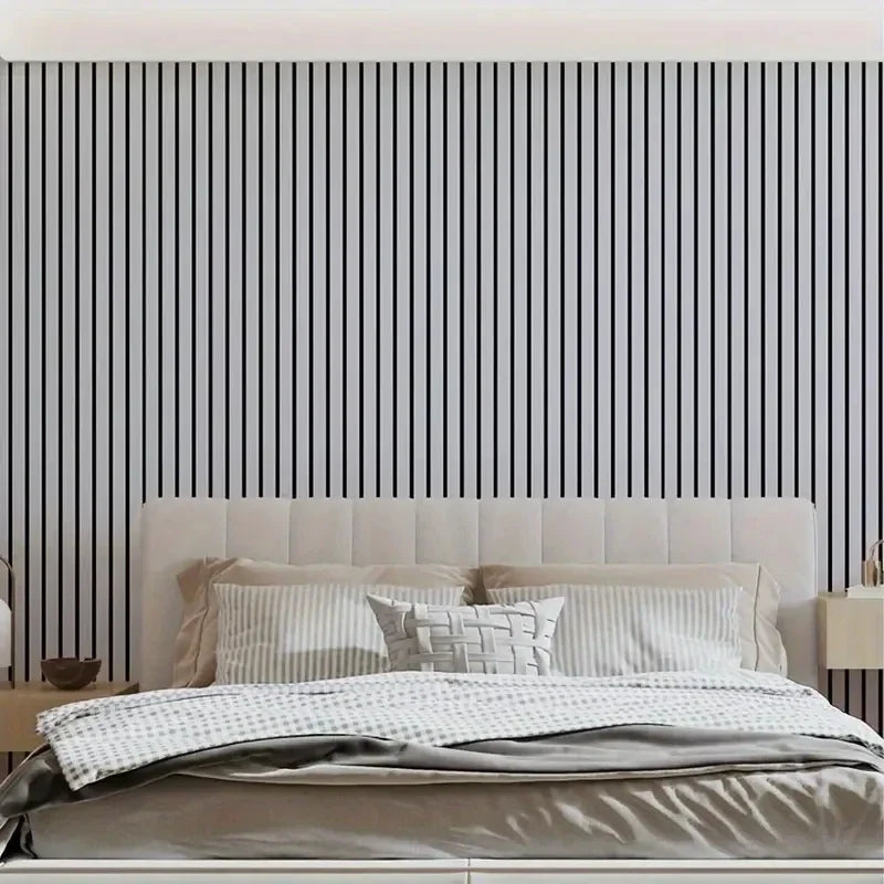 A bedroom featuring a bed with white linens against a dark gray and white vertical striped wallpaper.