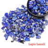 A pile of deep blue lapis lazuli crystal stone chips and tumbled stones.