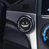 Close-up of a black rotating protective cover for a car ignition start button with engine start and stop markings