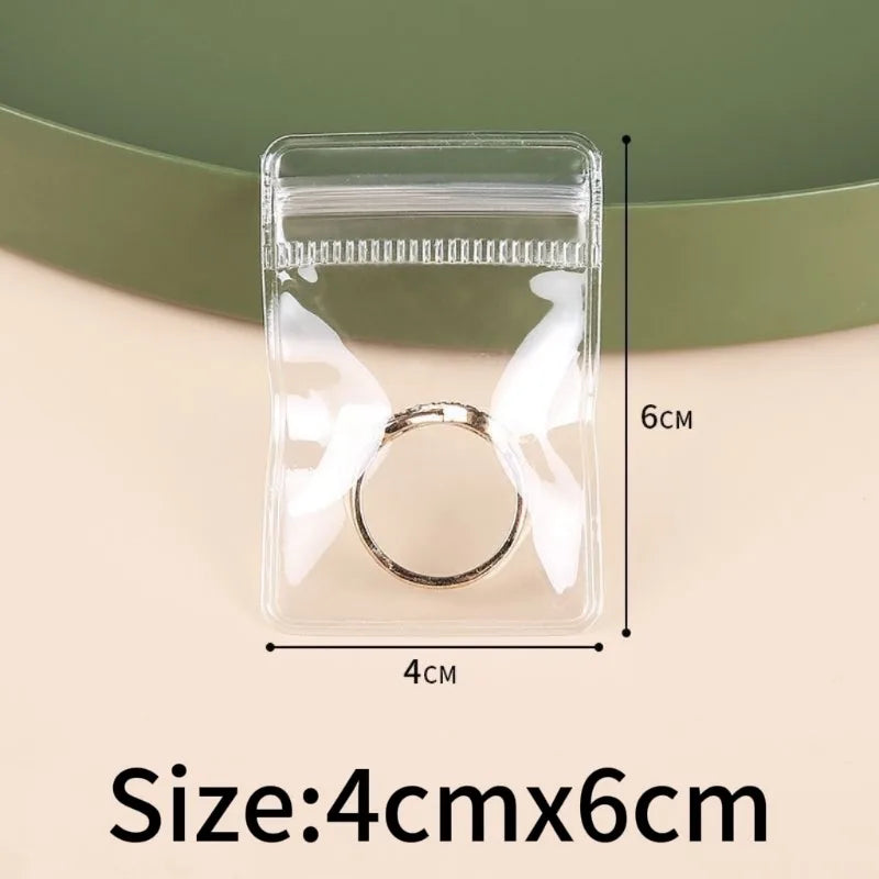 A clear self-sealing jewelry storage bag containing a silver ring, shown against a light background.