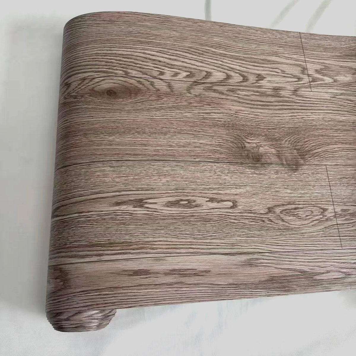 Close-up of a rectangular wood grain PVC self-adhesive decal showing natural brown and gray wood patterns.