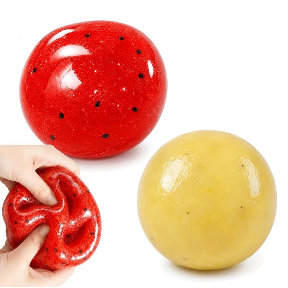 Una esfera suave de alivio de estrés en forma de sandía roja brillante junto a una versión en forma de calabaza amarilla.