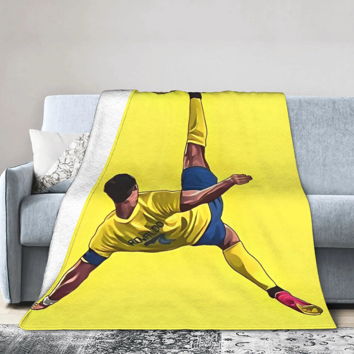 Gelber Überwurf mit Grafik eines Fußballspielers, der einen Ball tritt.
