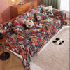 A romantic floral jacquard sofa blanket draped over a sofa with decorative pillows and black and white socks.
