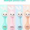 Multiple pastel color musical rabbit baby rattle and teether toys shown in various shades of mint green, pink, and peach.