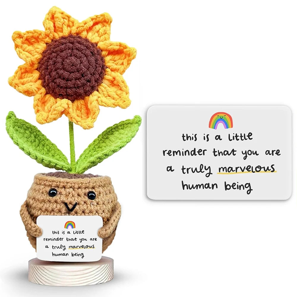 Hand-crocheted orange sunflower with a brown center growing in a pot, featuring a humorous message.