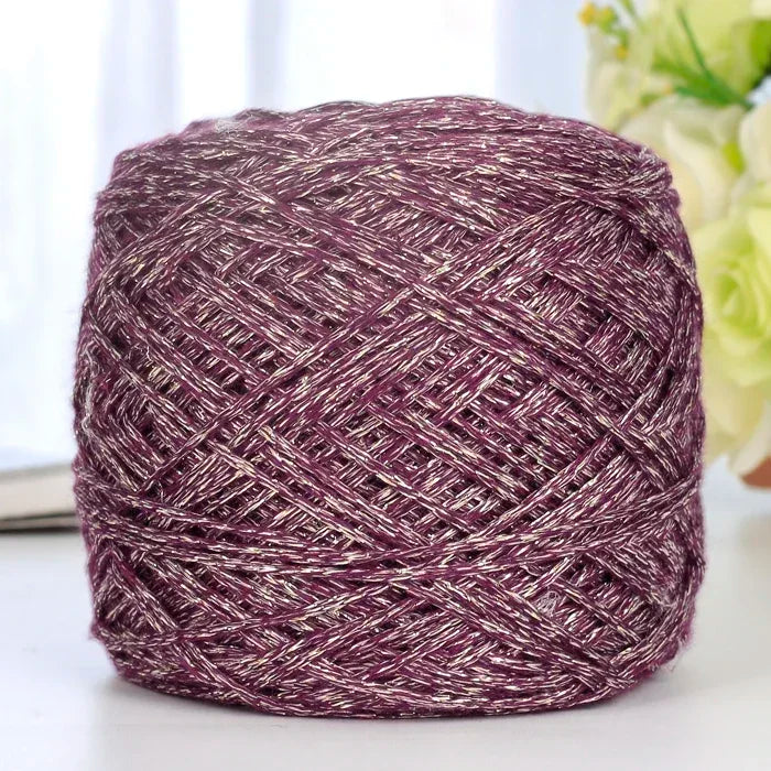 A ball of metallic purple silk crochet yarn with silver shimmer thread for knitting and macrame.