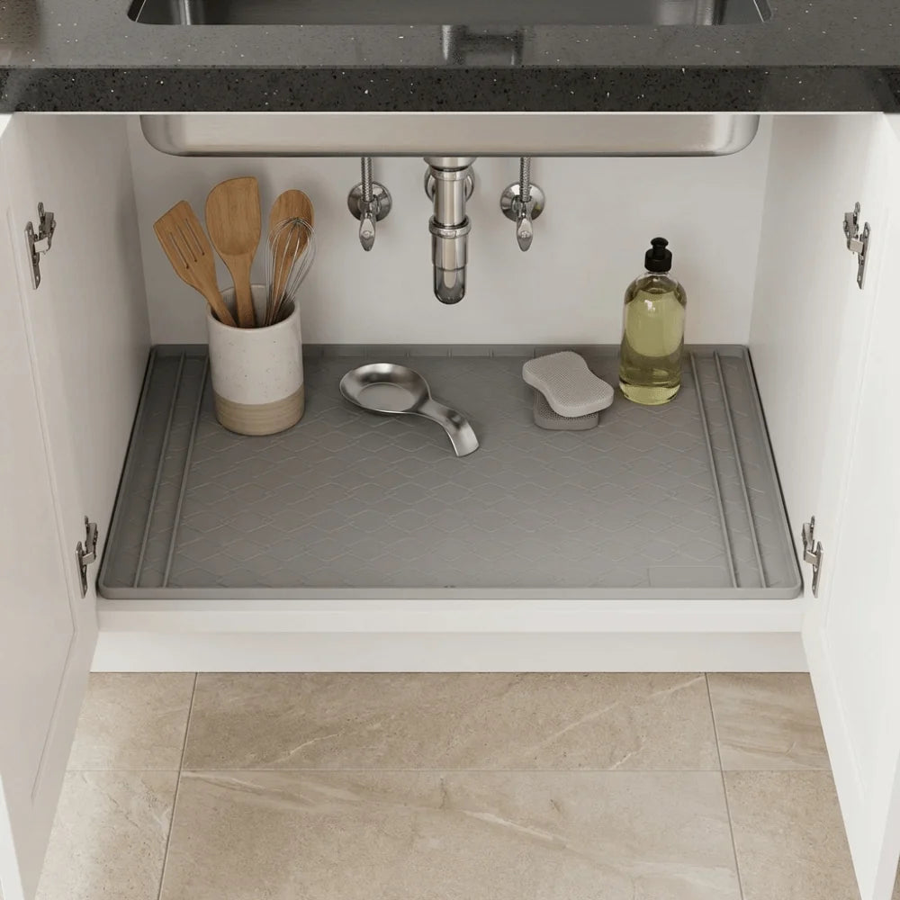A silicone mat placed inside a kitchen sink cabinet to protect the surface.