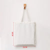 A white canvas shopping tote bag with a wooden handle, shown against a white background.