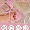 A pink silicone chick glove teether is shown being used by a baby's hand for gum relief.