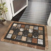 A rectangular farmhouse geometric kitchen mat with a distressed brown and gray pattern rests on a wooden floor.