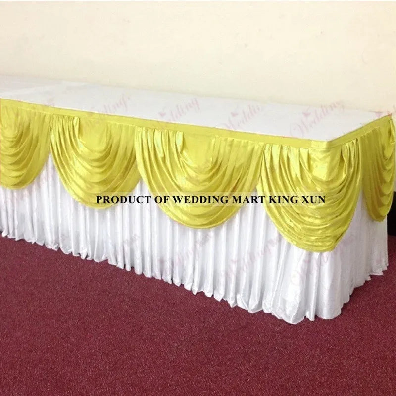 Elegant ice silk table skirt with matching top swag in white and gold fabric.