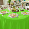 A bright green disposable round tablecloth set for parties with yellow floral accents and glassware.