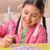 A girl is making friendship bracelets using colorful beads and string on a yellow table.