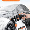 A hand is using a white electric foam pot sprayer to wash snow off a car tire.