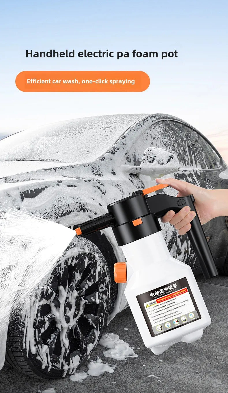 A hand is using a white electric foam pot sprayer to wash snow off a car tire.
