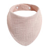 A light pink organic cotton muslin baby bib with a textured surface and adjustable band.