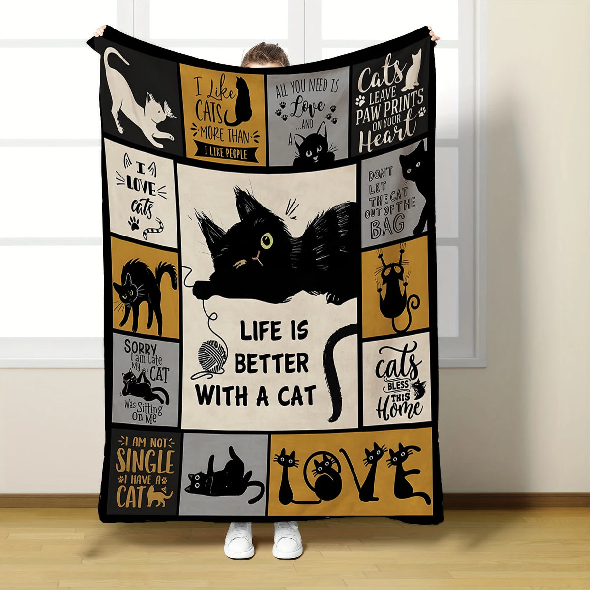 A black flannel throw blanket featuring various cat-themed quotes and illustrations on a light background.