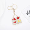 A crystal rhinestone handbag keychain with a red and white design is shown against a white background.